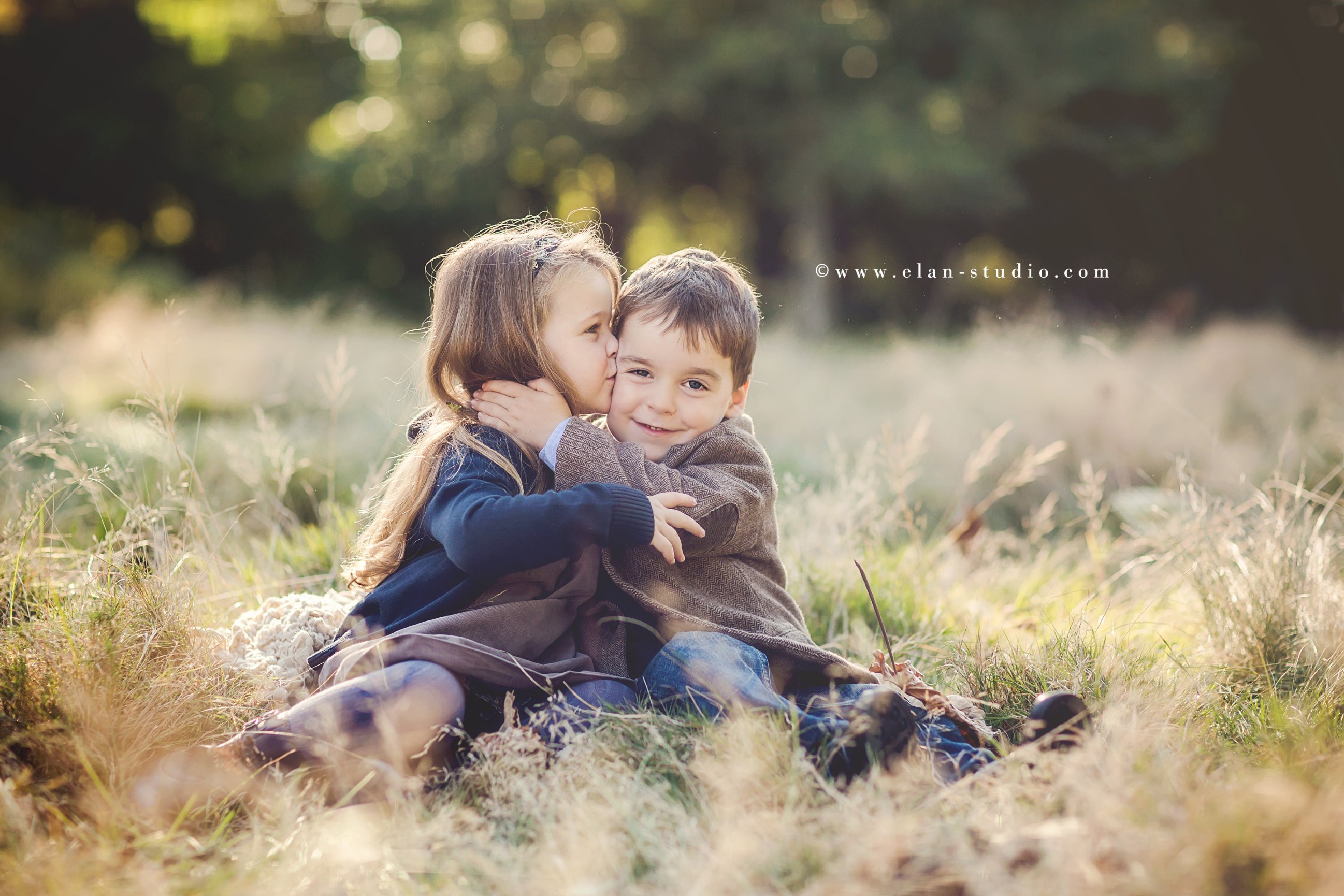 sister kissing little brother on the cheek