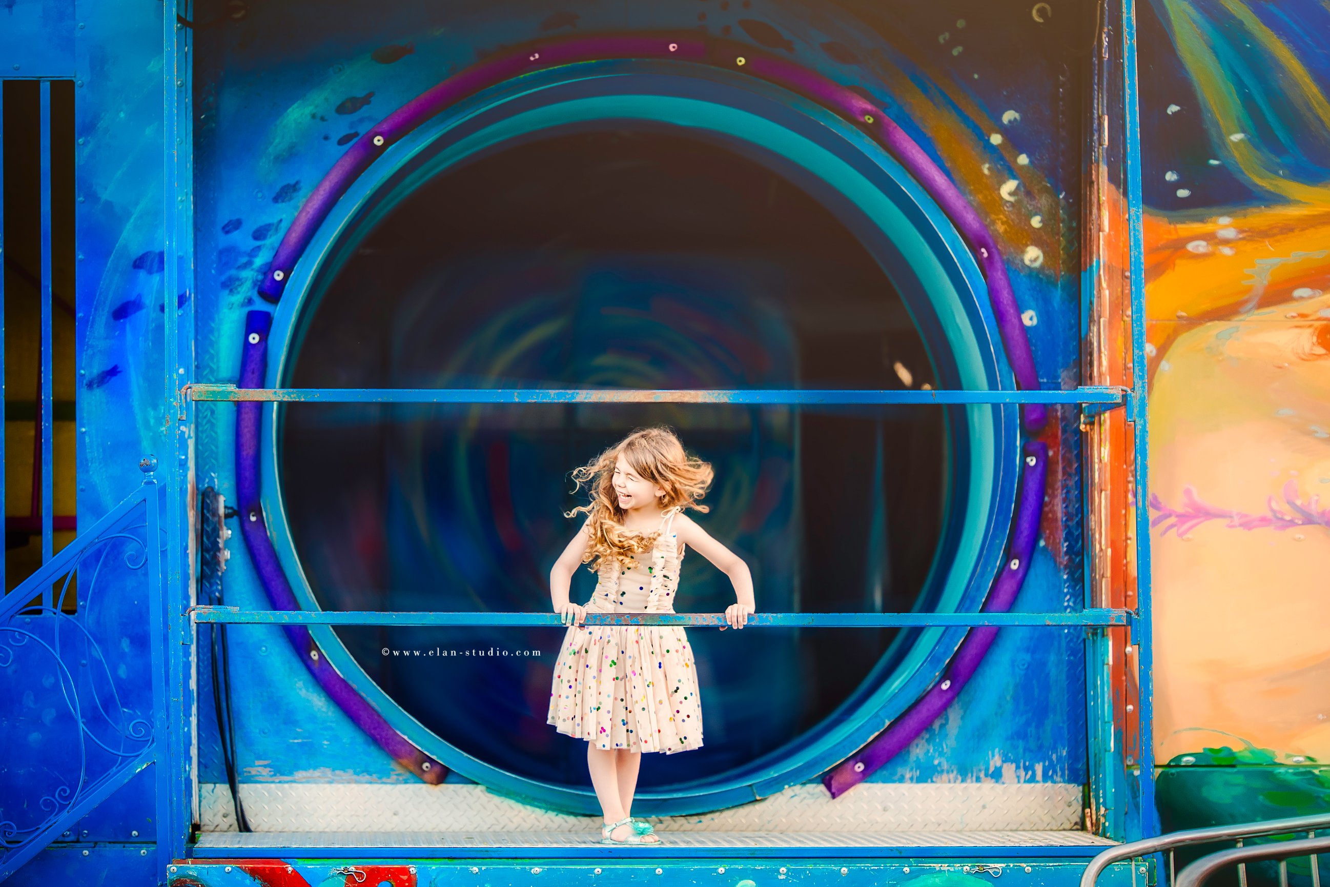 happy girl in front of painted carnival fun house