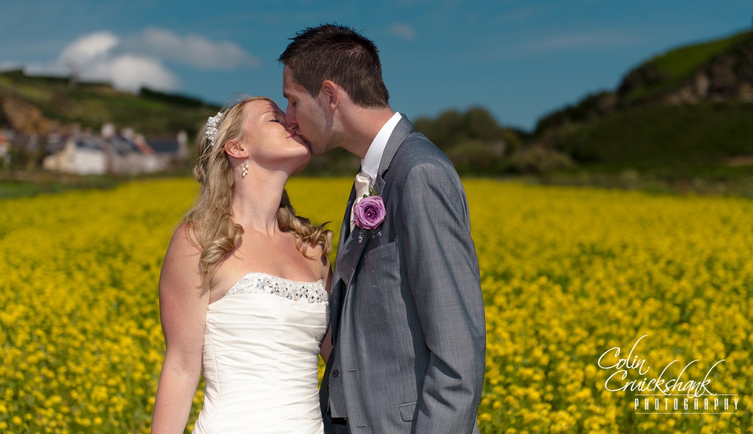 bride and groom in field of rape seed Jersey