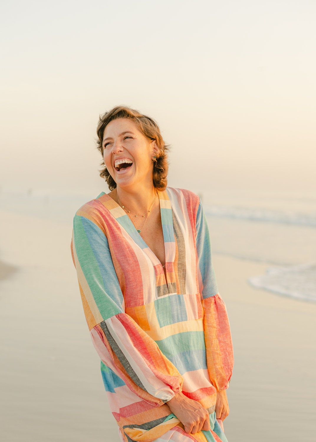 cancer survivor laughing and wearing a long rainbow dress, Ryaphotos