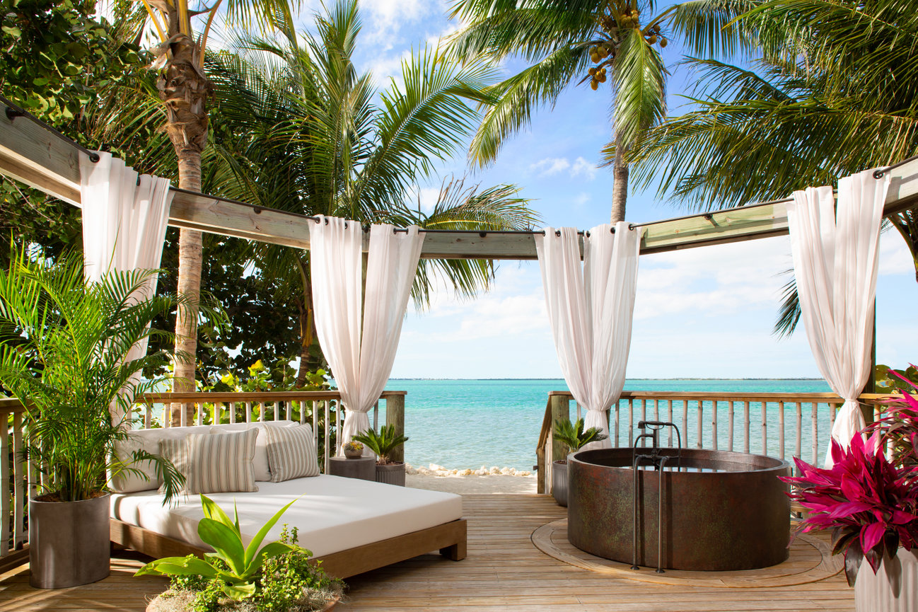 Guest room outside Deck at Little Palm Island with Lush Palm Trees, Jacuzzi and beautiful selected furniture on the Gulf of Mexico Ocean in the Florida Keys.