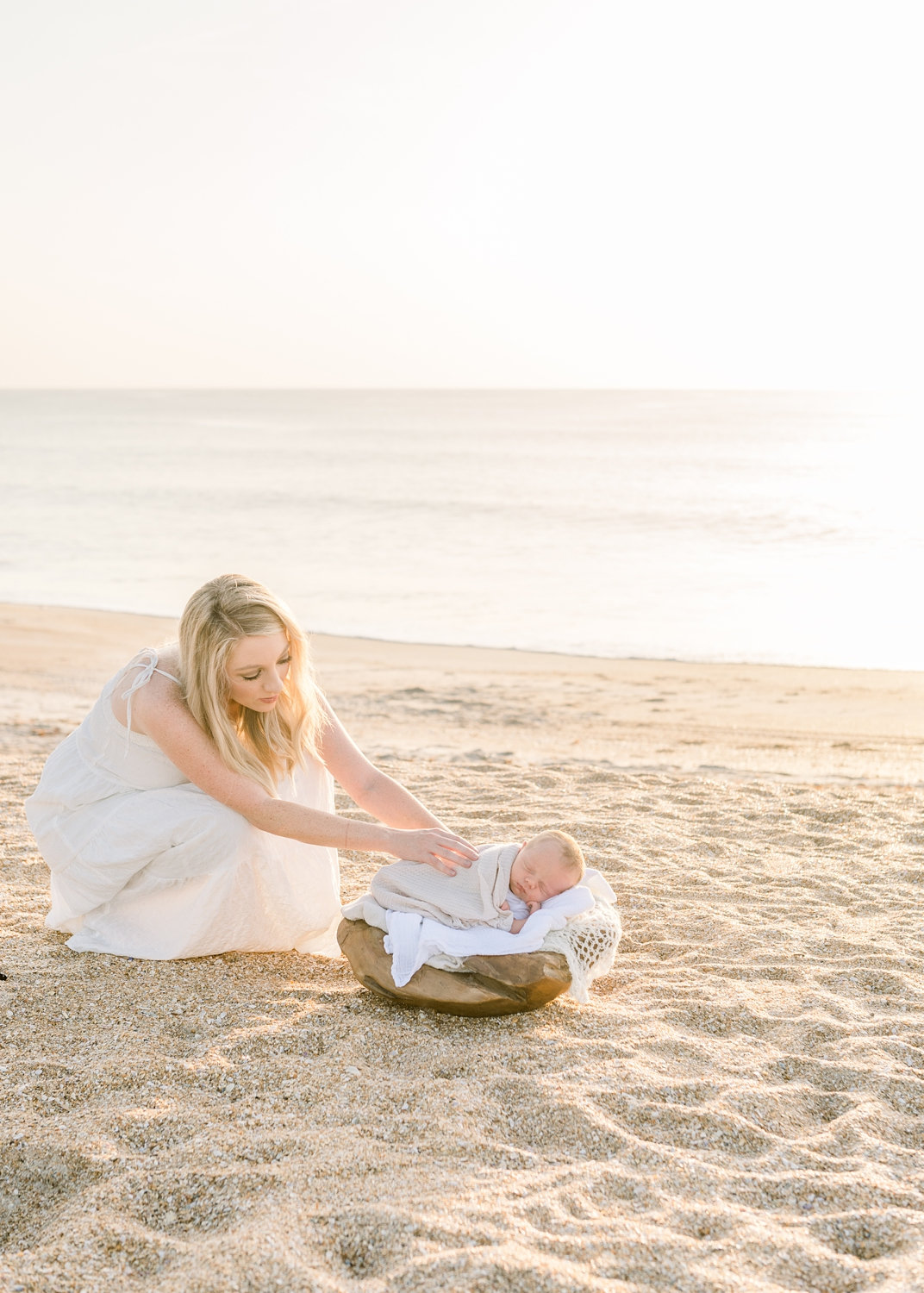 mother tucking newborn boy into cradle, wooden cradle prop, Ryaphotos