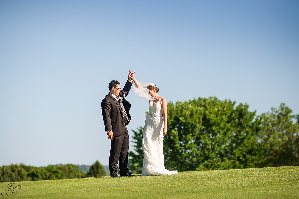 bride and groom dancing outside on golf course