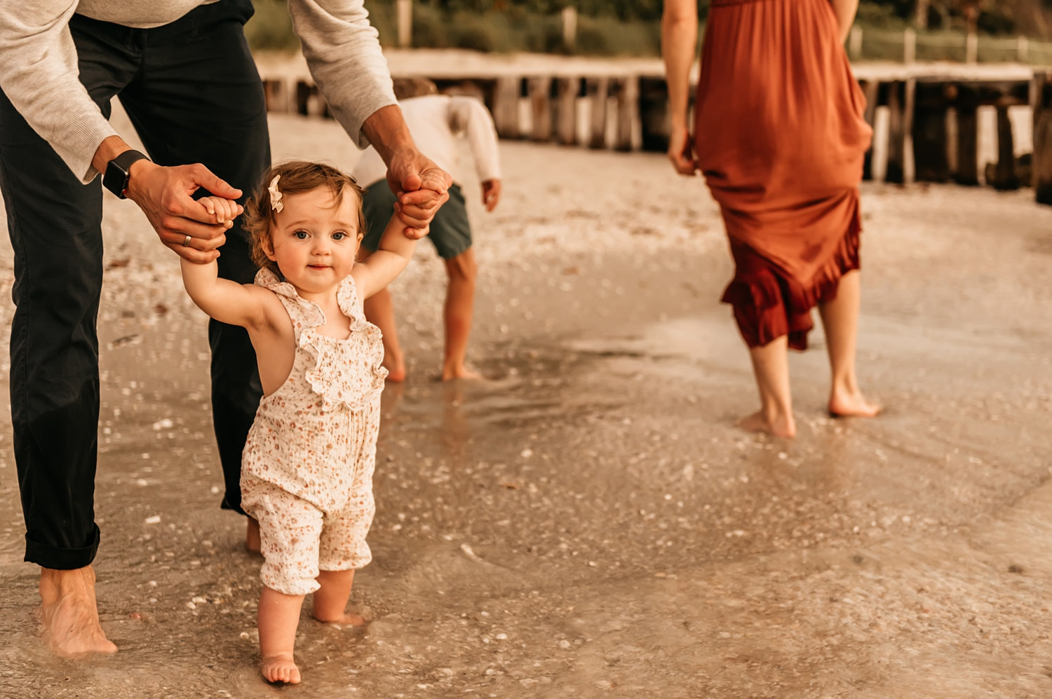 baby beach portrait with family in background, toes in the water, Rya Duncklee