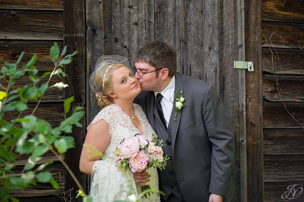 beautiful image of groom kissing bride on the cheek