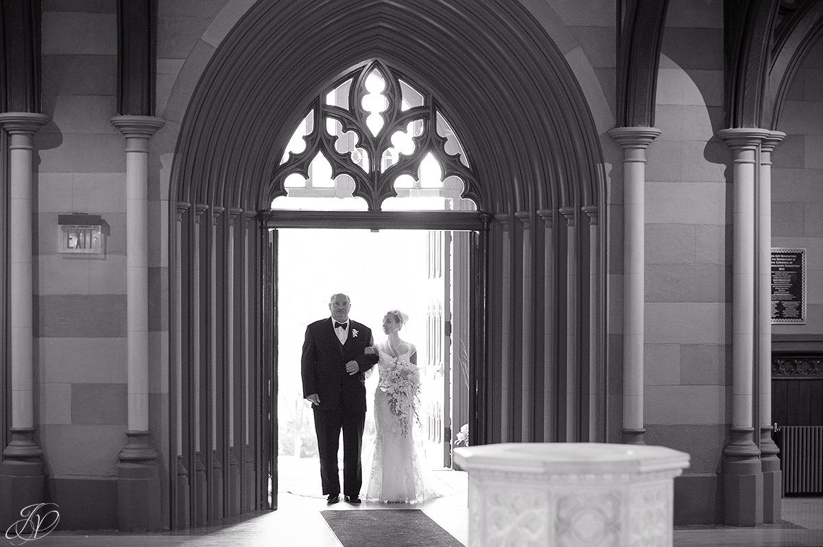 father walking daughter down the aisle at church black and white