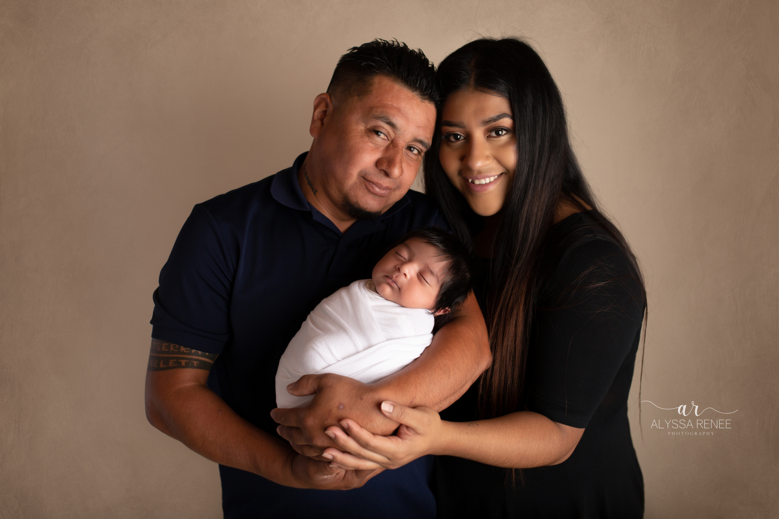 mom and dad with swaddled infant portrait by Alyssa Renee Photography