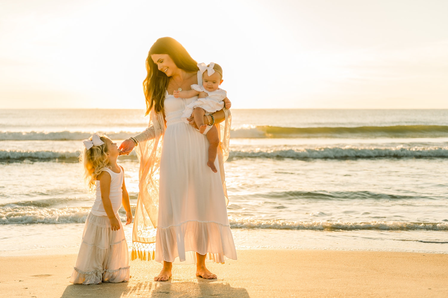 mother holding a baby and looking down at her little girl, Ponte Vedra Beach sunrise