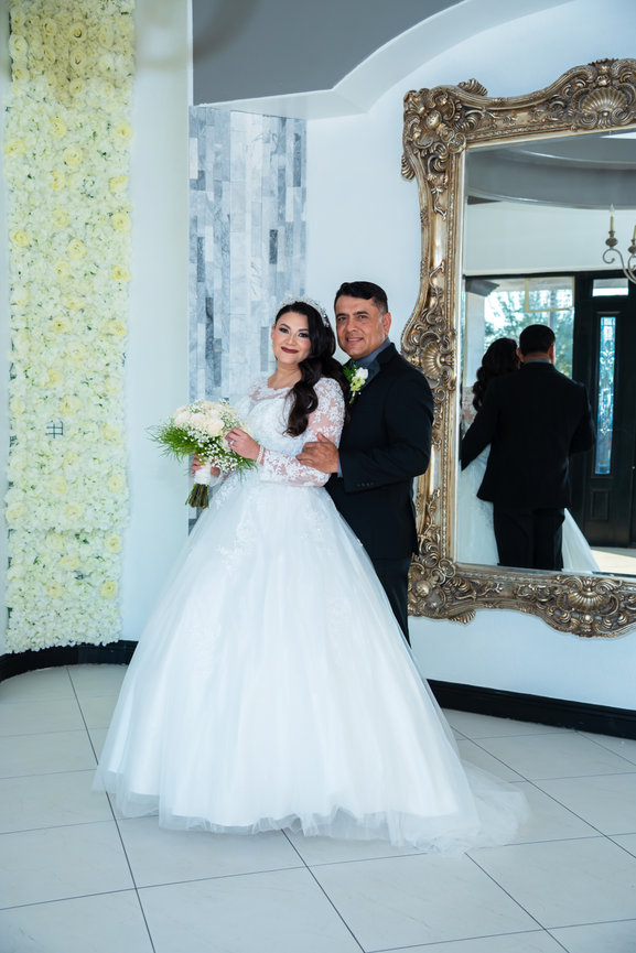 Wedding couple posing indoors with mirror backdrop