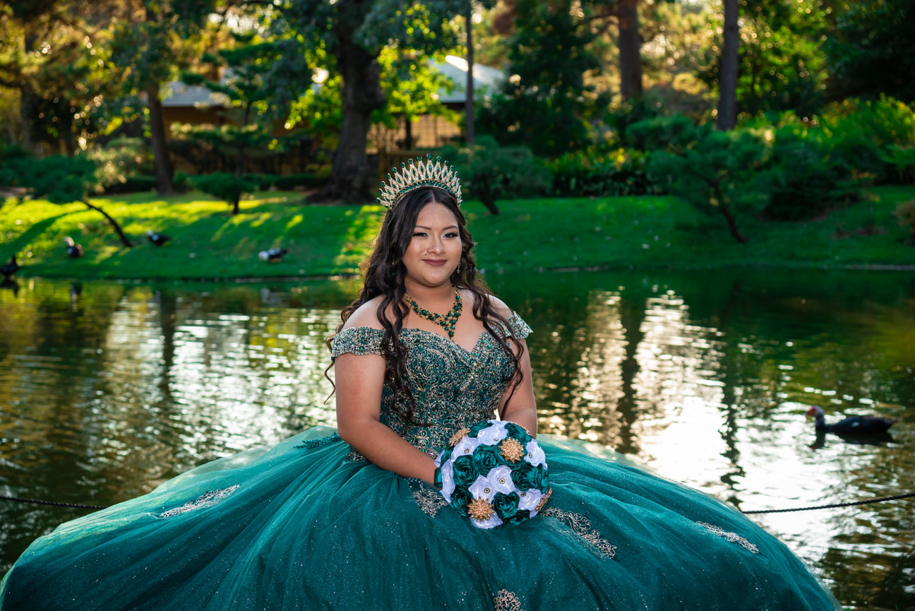 Young woman in green gown by reflective water