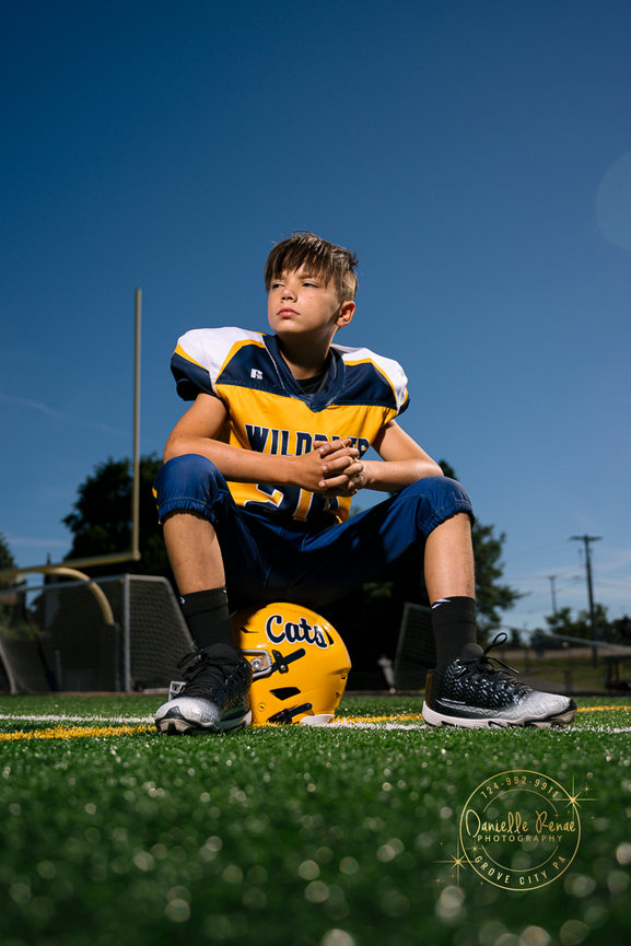 football player sitting on his helmet in the endzone