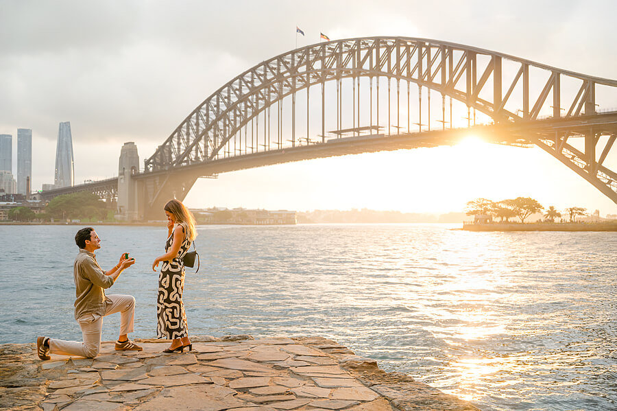 Man proposing to a woman during a photoshoot with a Sydney proposal photographer with Sydney Harbour Bridge
