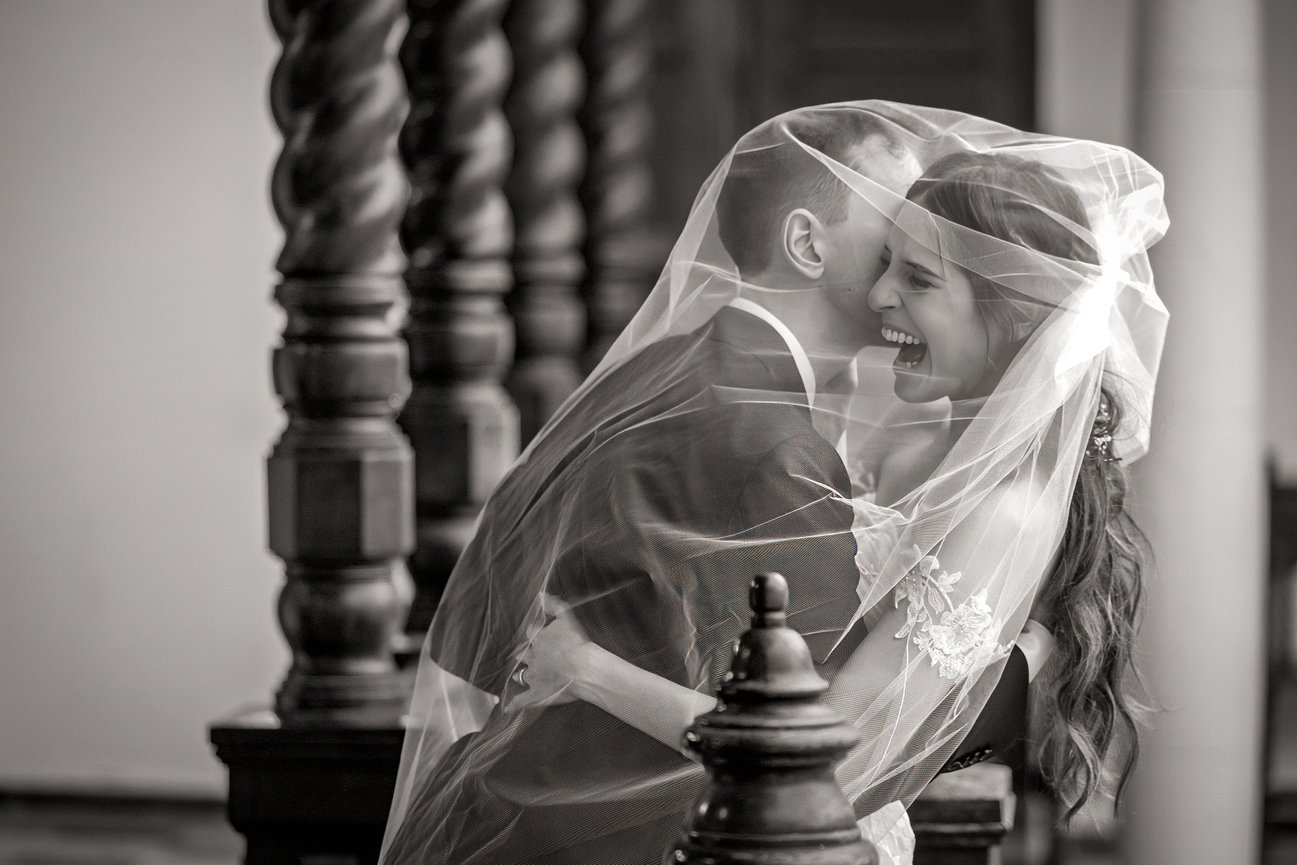 Black-and-white wedding portrait beneath the bridal veil