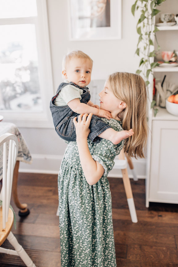A young girl holds her baby brother in a Huntsville alabama family photoshoot