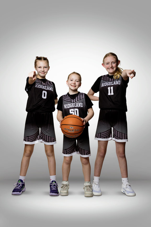 Three youth basketball players posing together