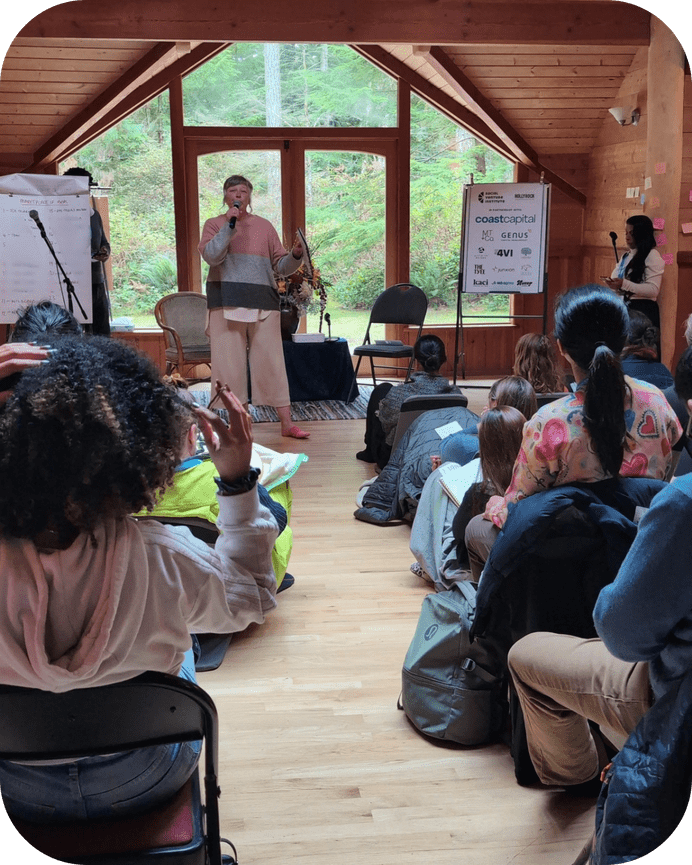 Image of Lisa Moffatt standing at the front of a room while teaching at a leadership retreat