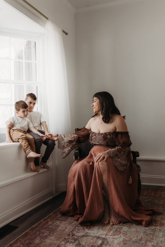 A woman sitting with her two sons in a Mendham, Photography studio.