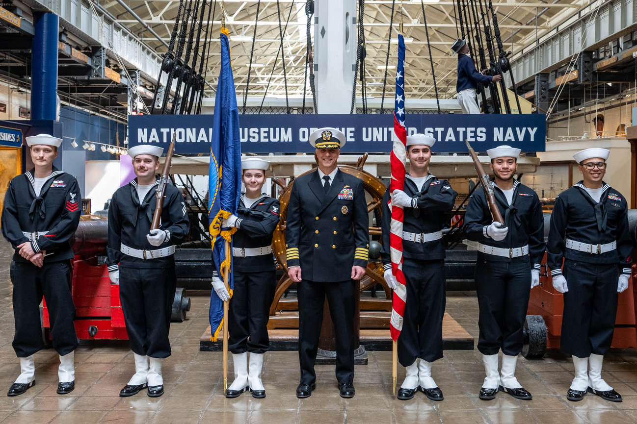 Naval Officer posing with a ceremonial guard during his retirement ceremony