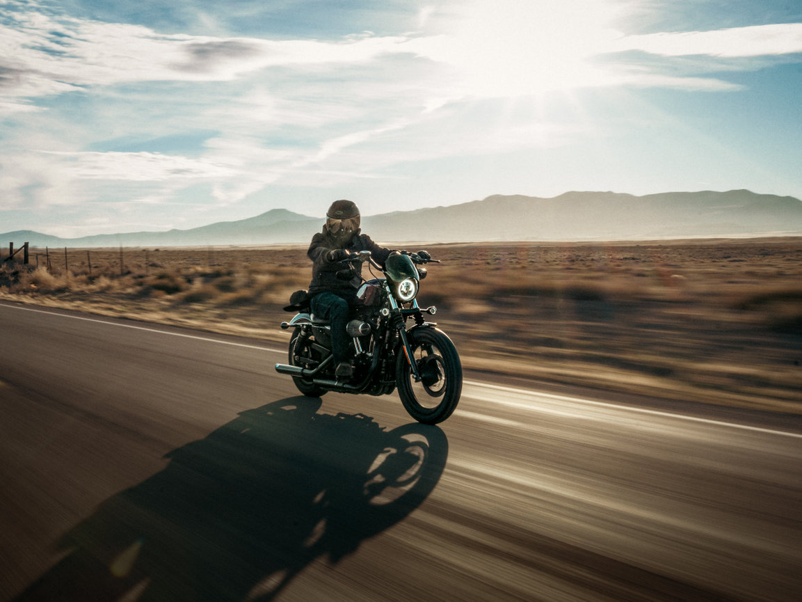 Motorcyclist riding a Harley-Davidson during a sunset roller shoot on an open road in Utah, capturing speed, freedom, and motion. Captured by Tre Nelson Photo