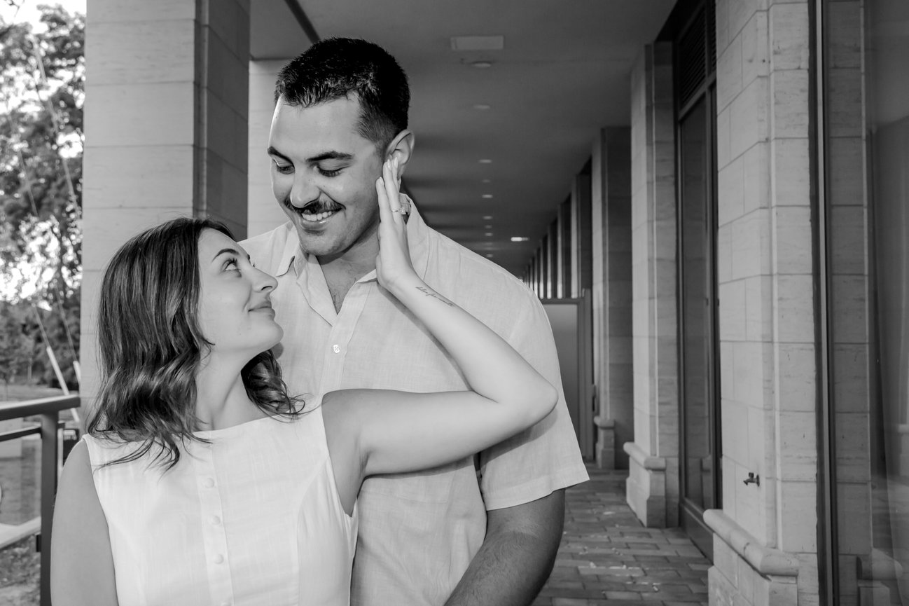 A couple smiles warmly at each other in a hallway.