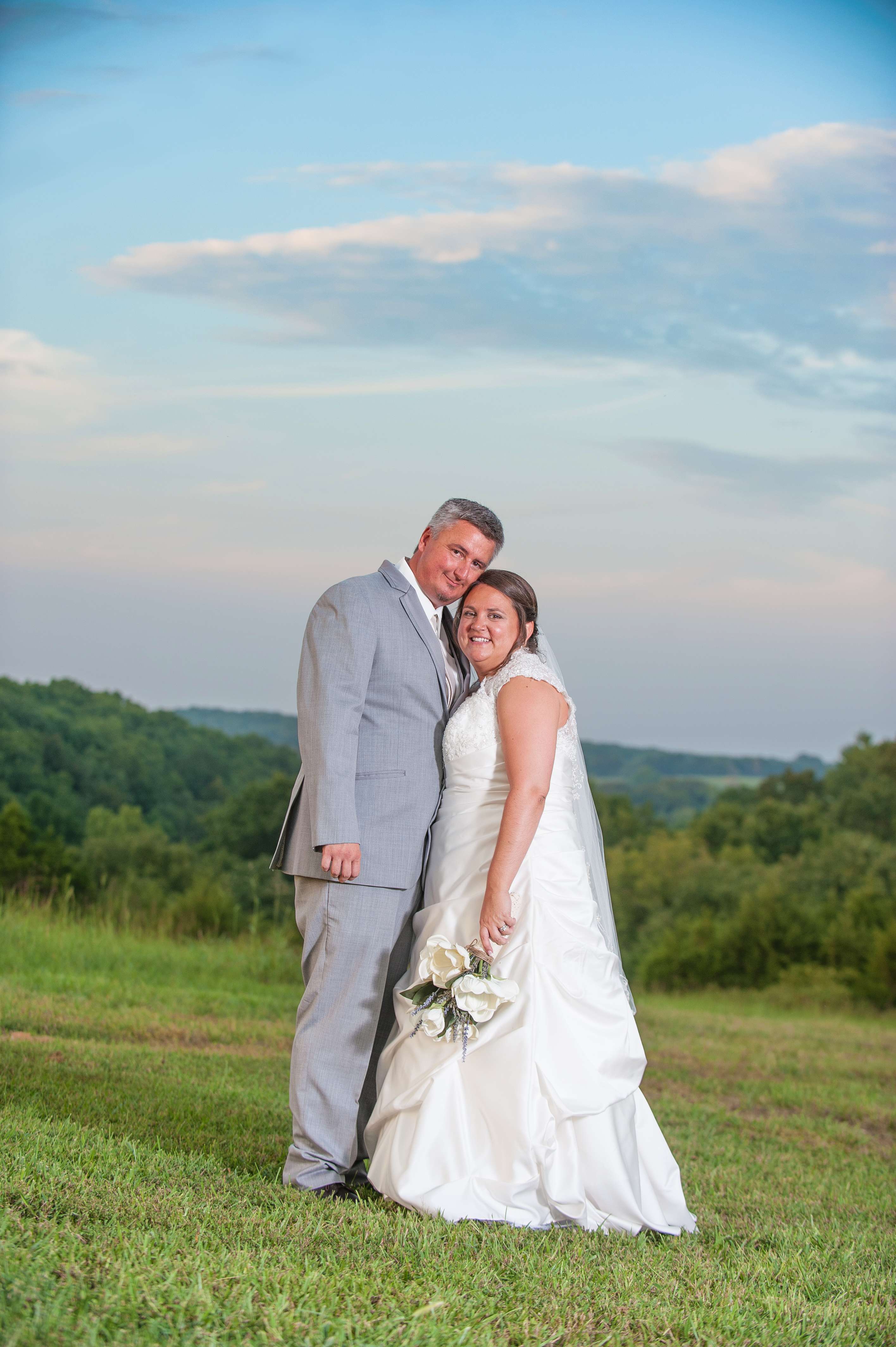 Wedding couple posing for portrait at sunset.