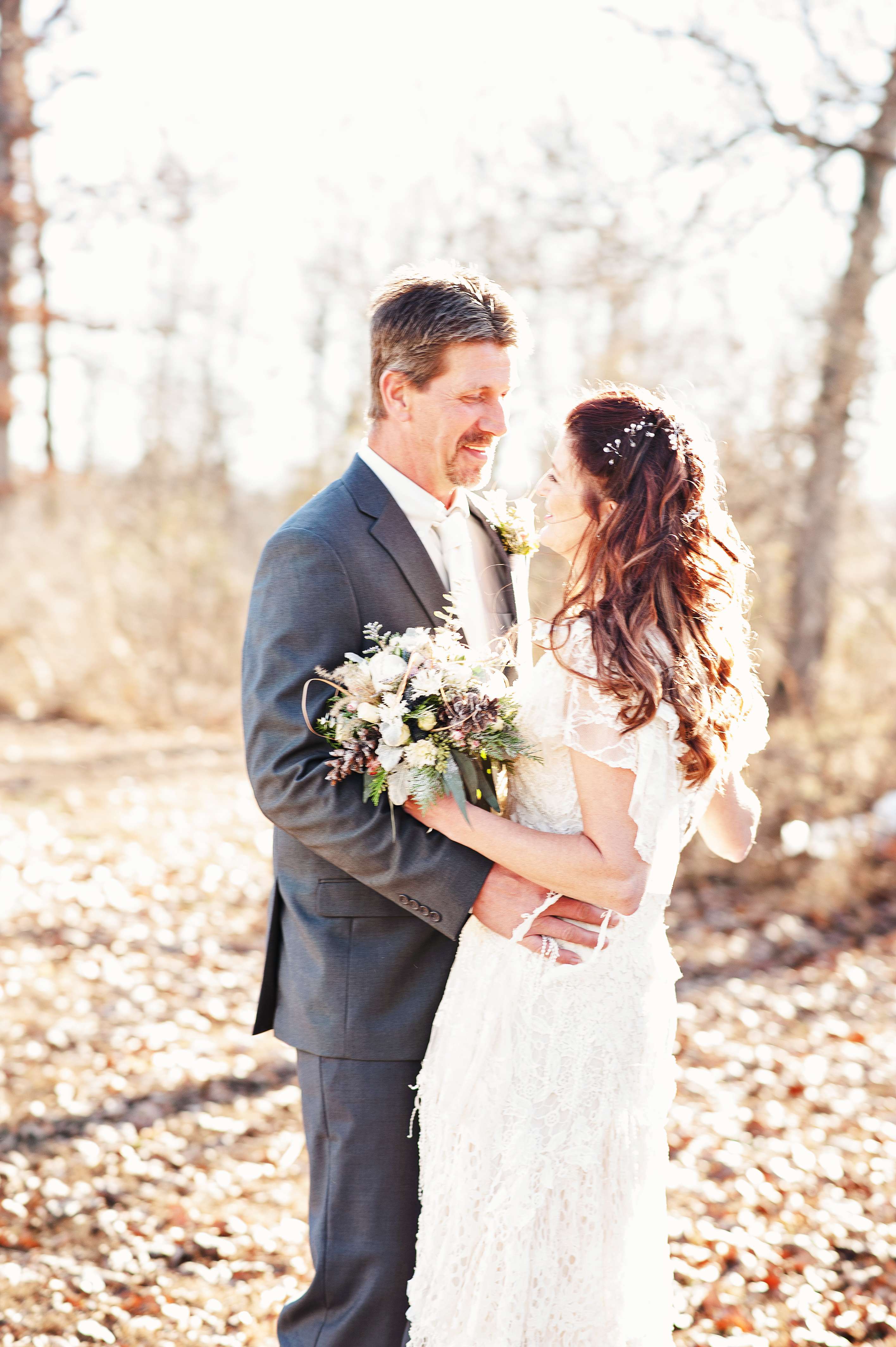 Bride and groom laughing and embracing at sunset.