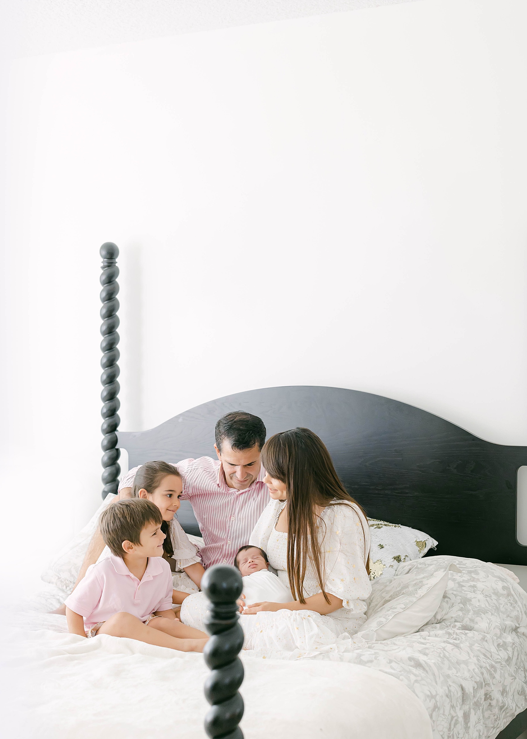 family sitting on bed together