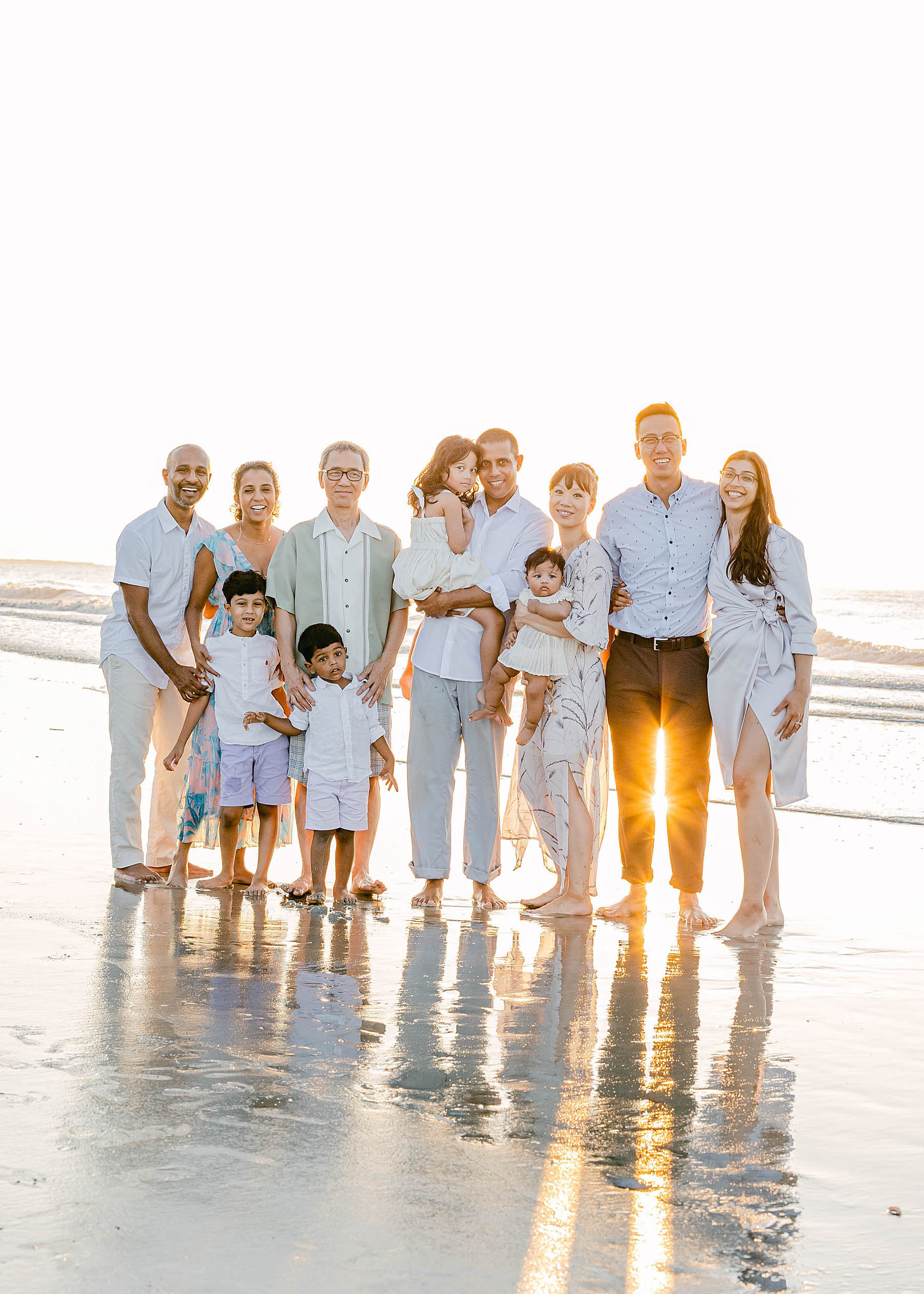 family standing together on the beach at sunrise