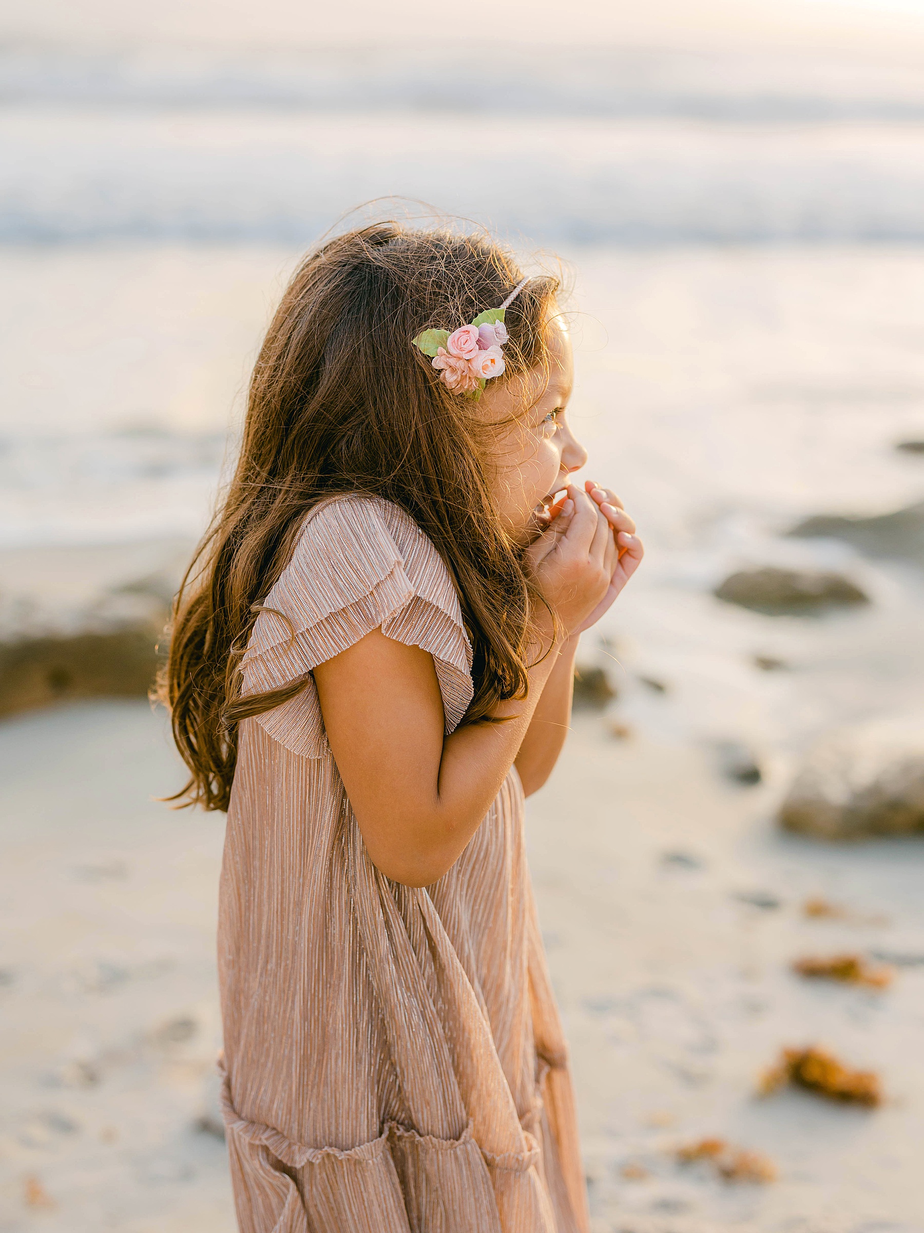 little girl giggling on the beach at sunrise