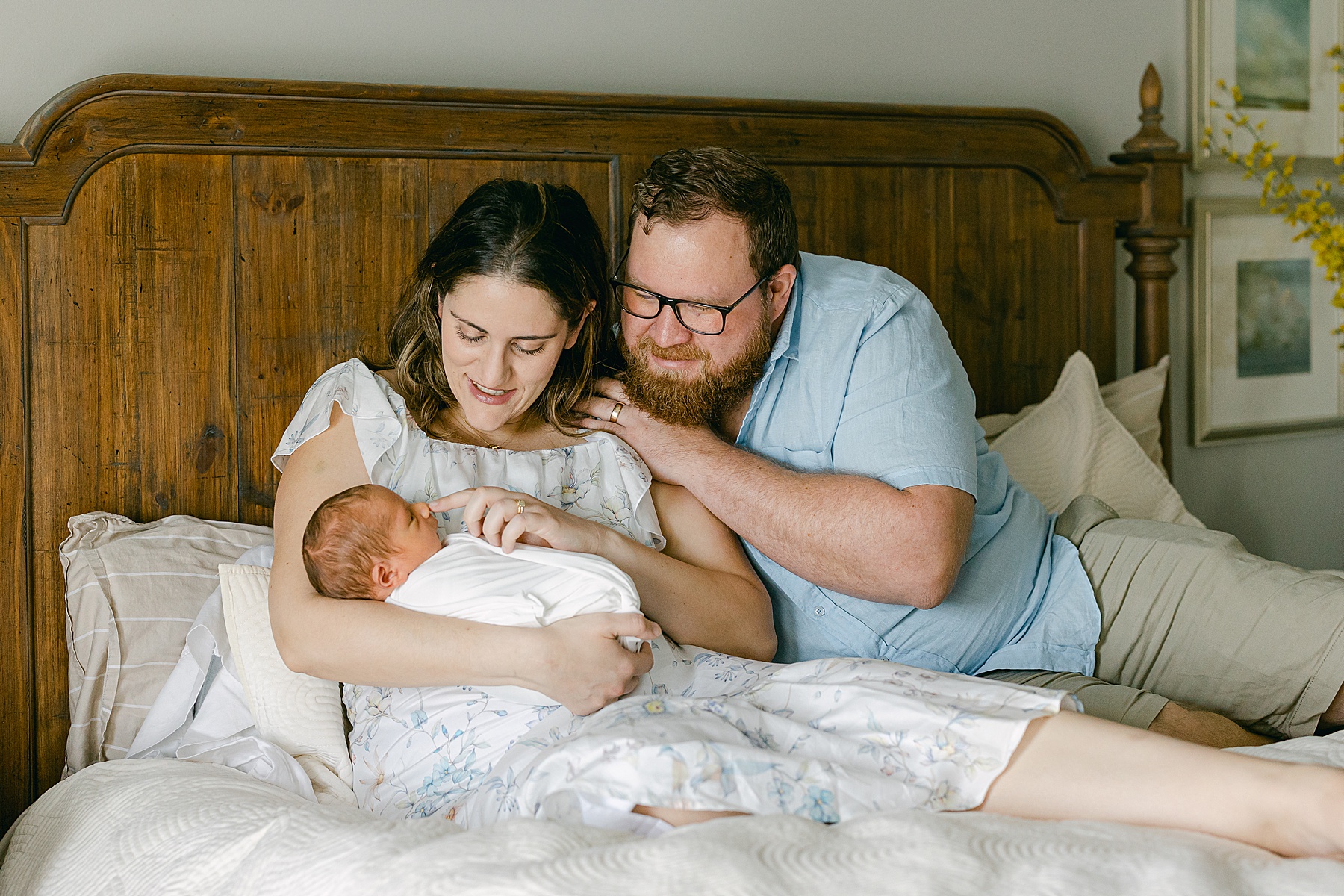 newborn baby being held my parents on a bed