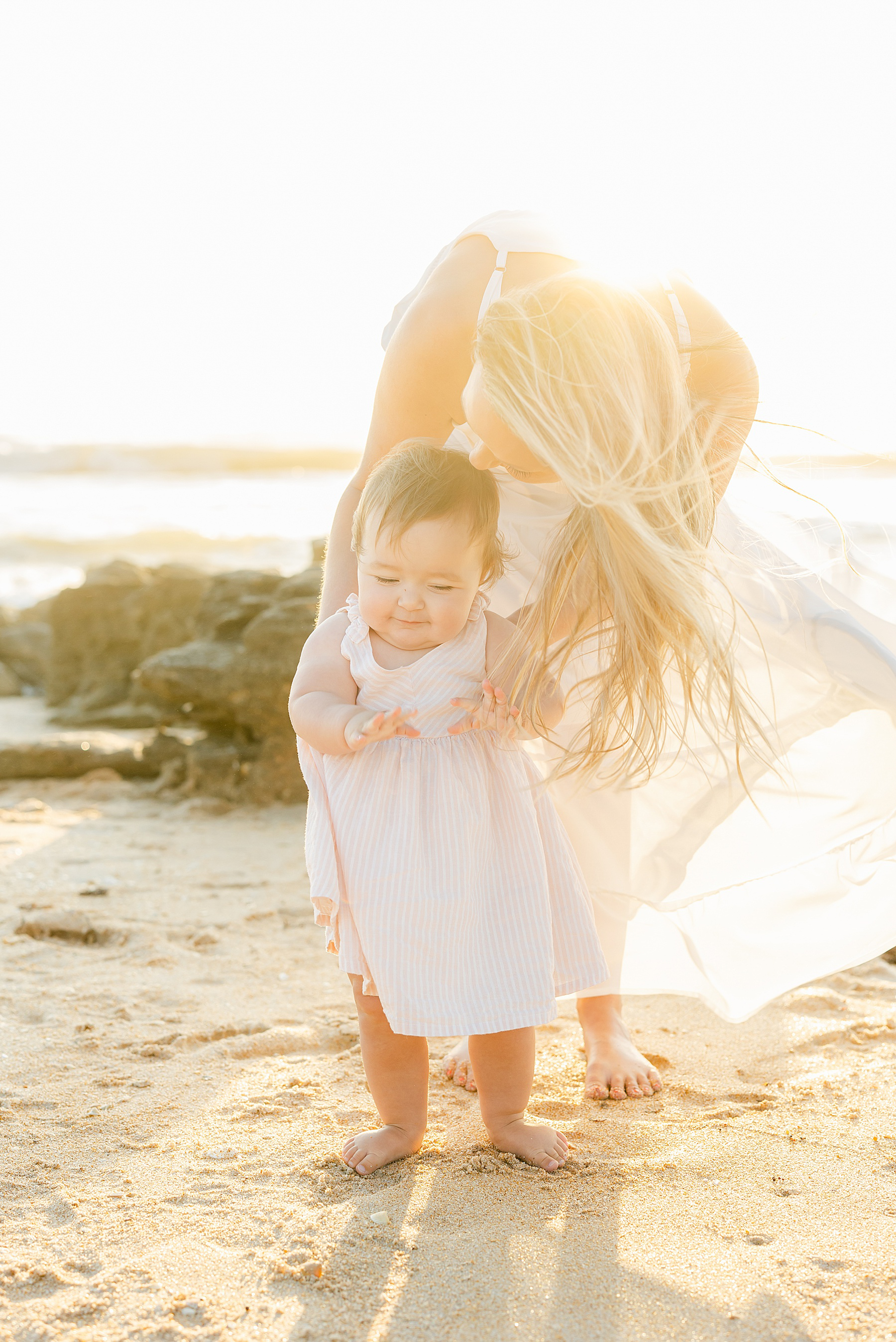 baby girl and her mama light and airy beach photo at sunrise florida pastel colors