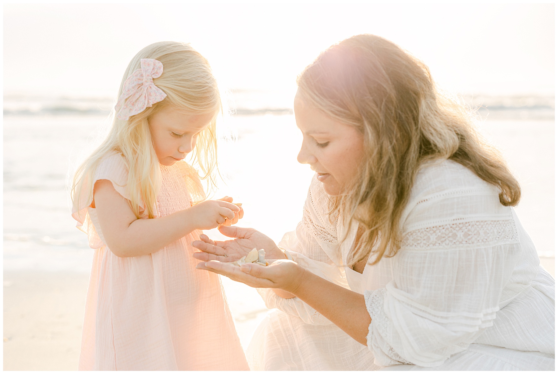 woman with blond haired daughter in pale pink dress on the beach at sunrise in saint augustine florida