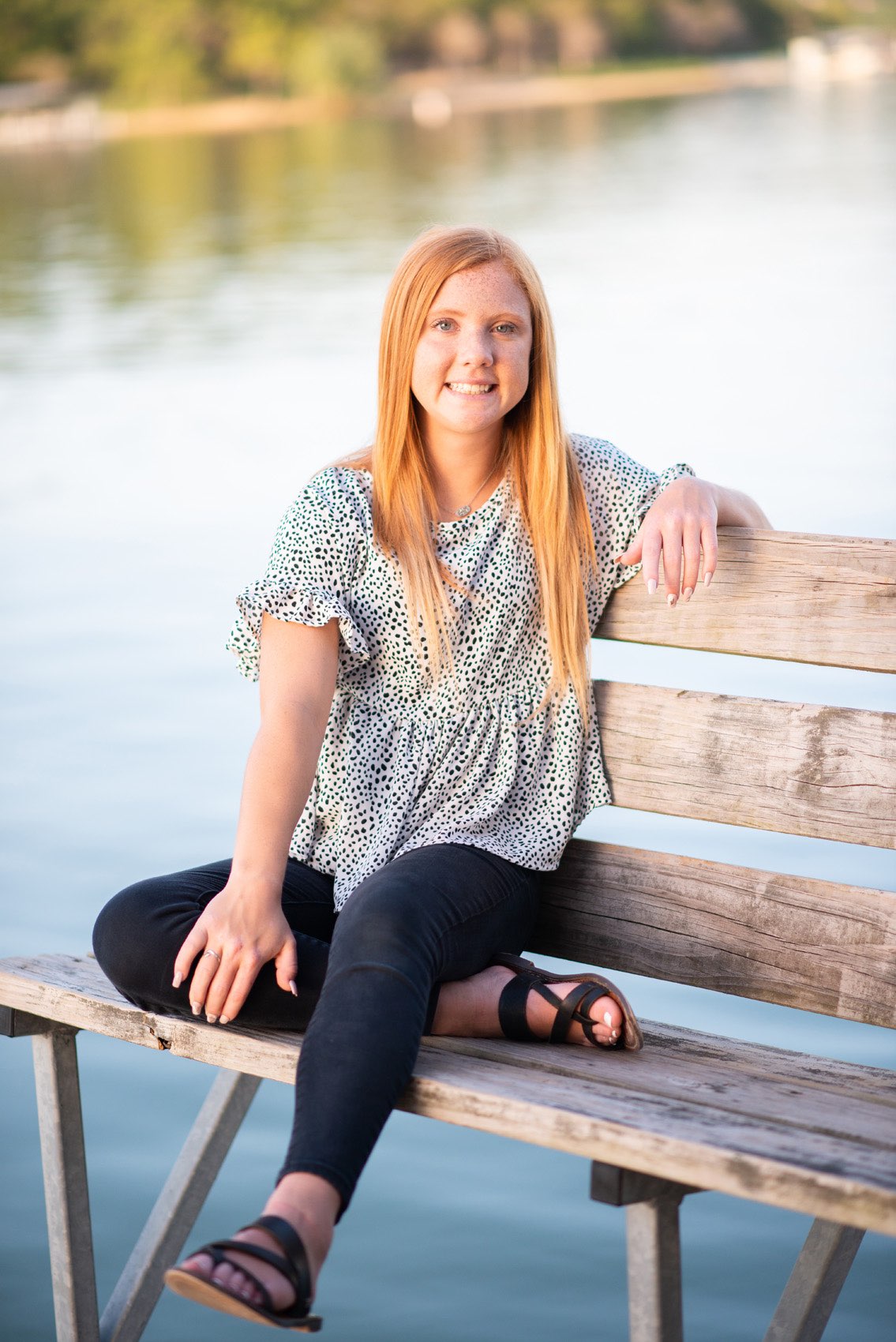 Senior girl at Tablerock Lake sitting on a bench.