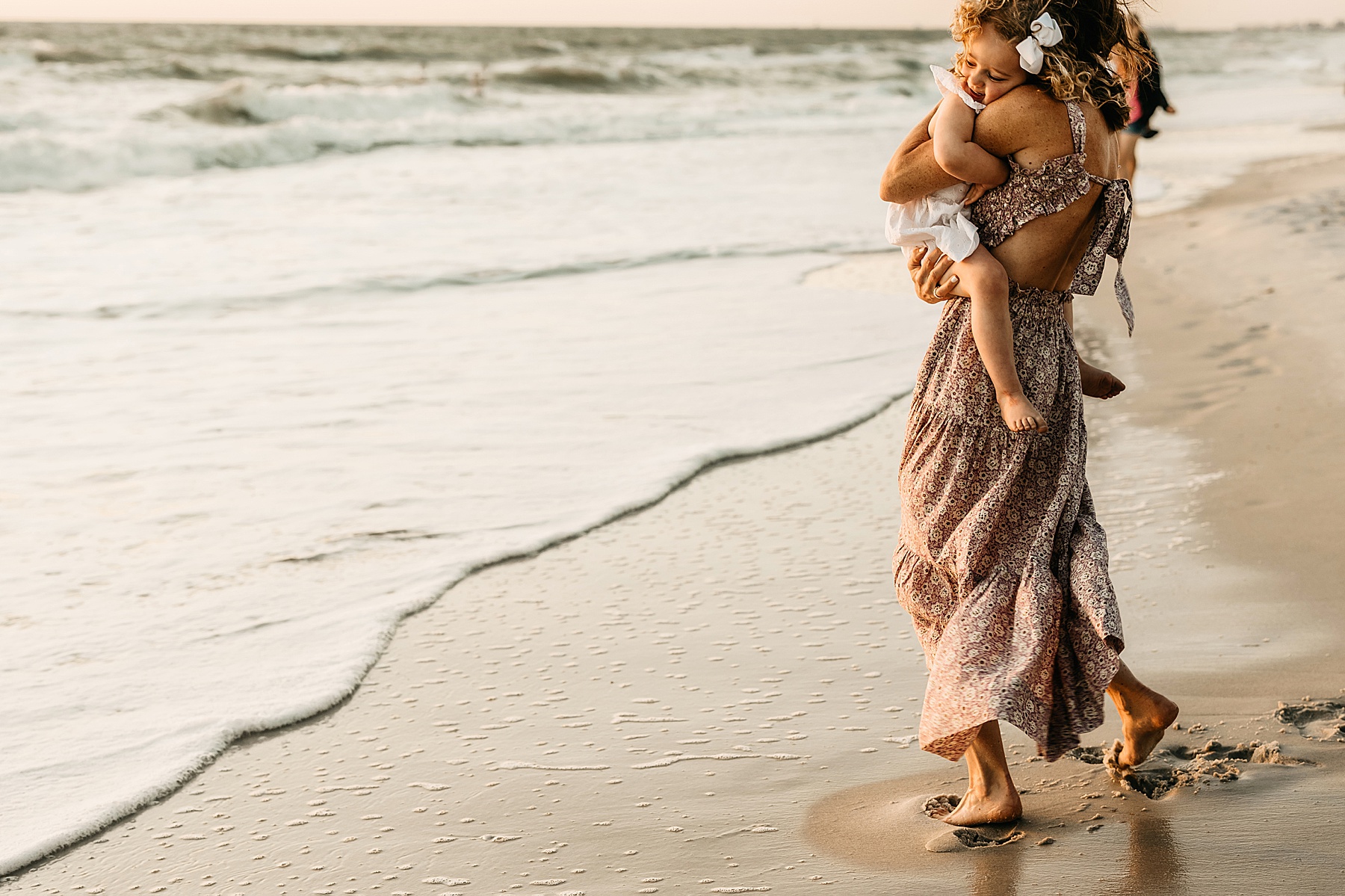 woman standing in the Gulf of Mexico at sunset in long flowing dress