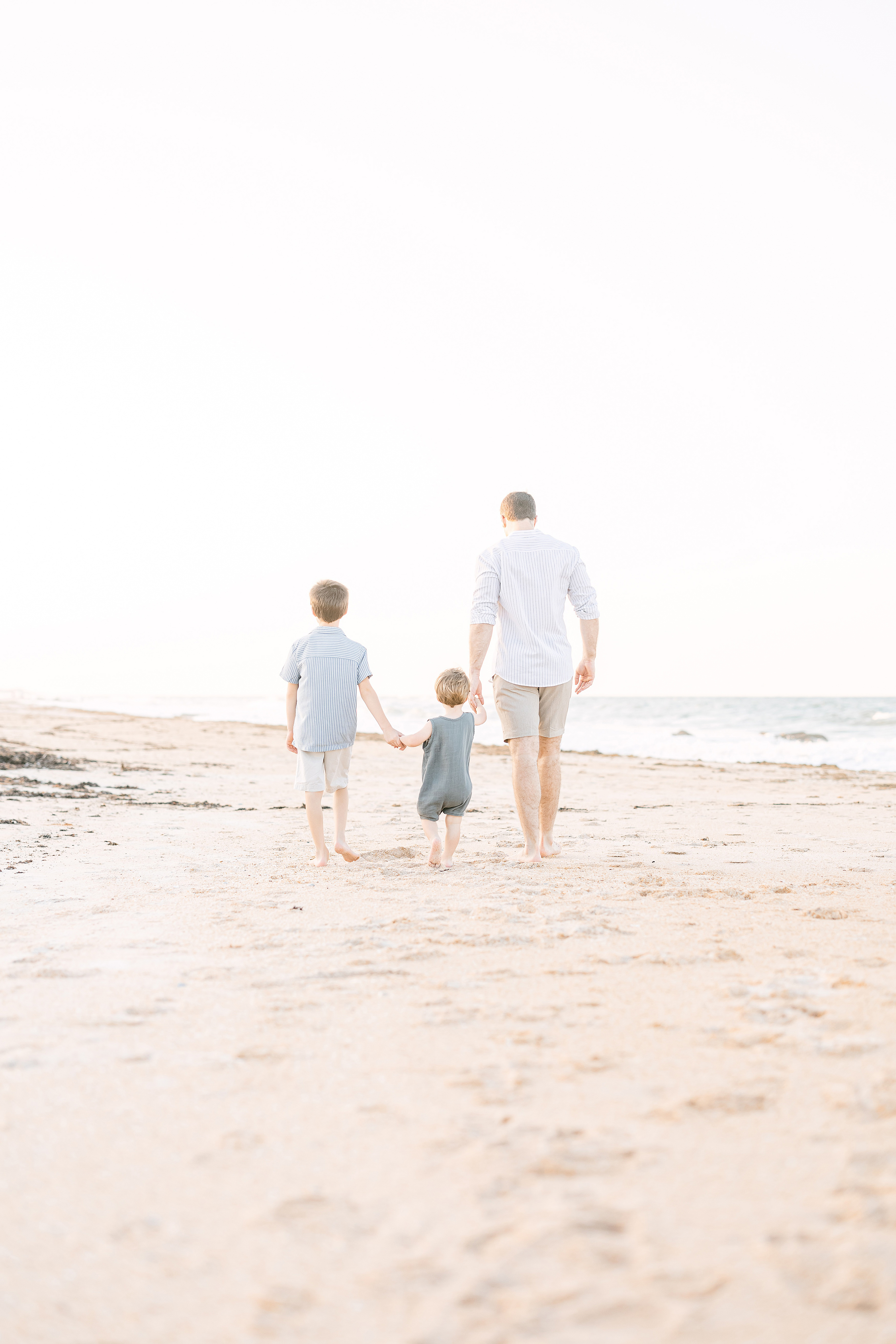 light and airy beach portrait of father with sons