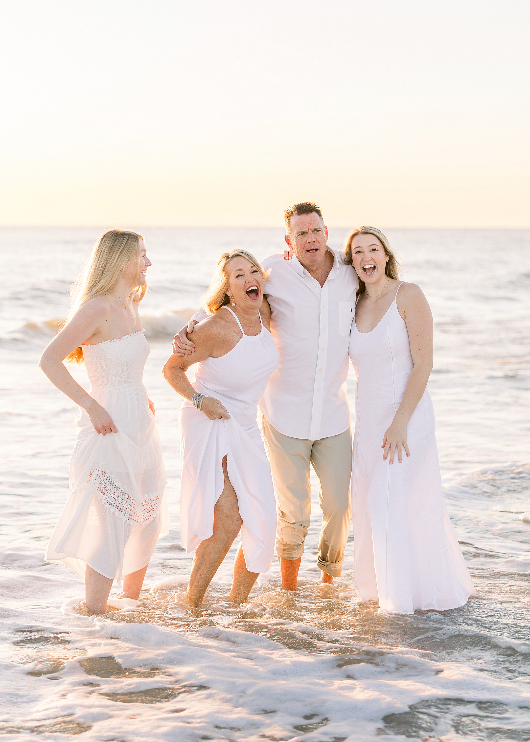 A sunrise family portrait of a family of four on the beach.