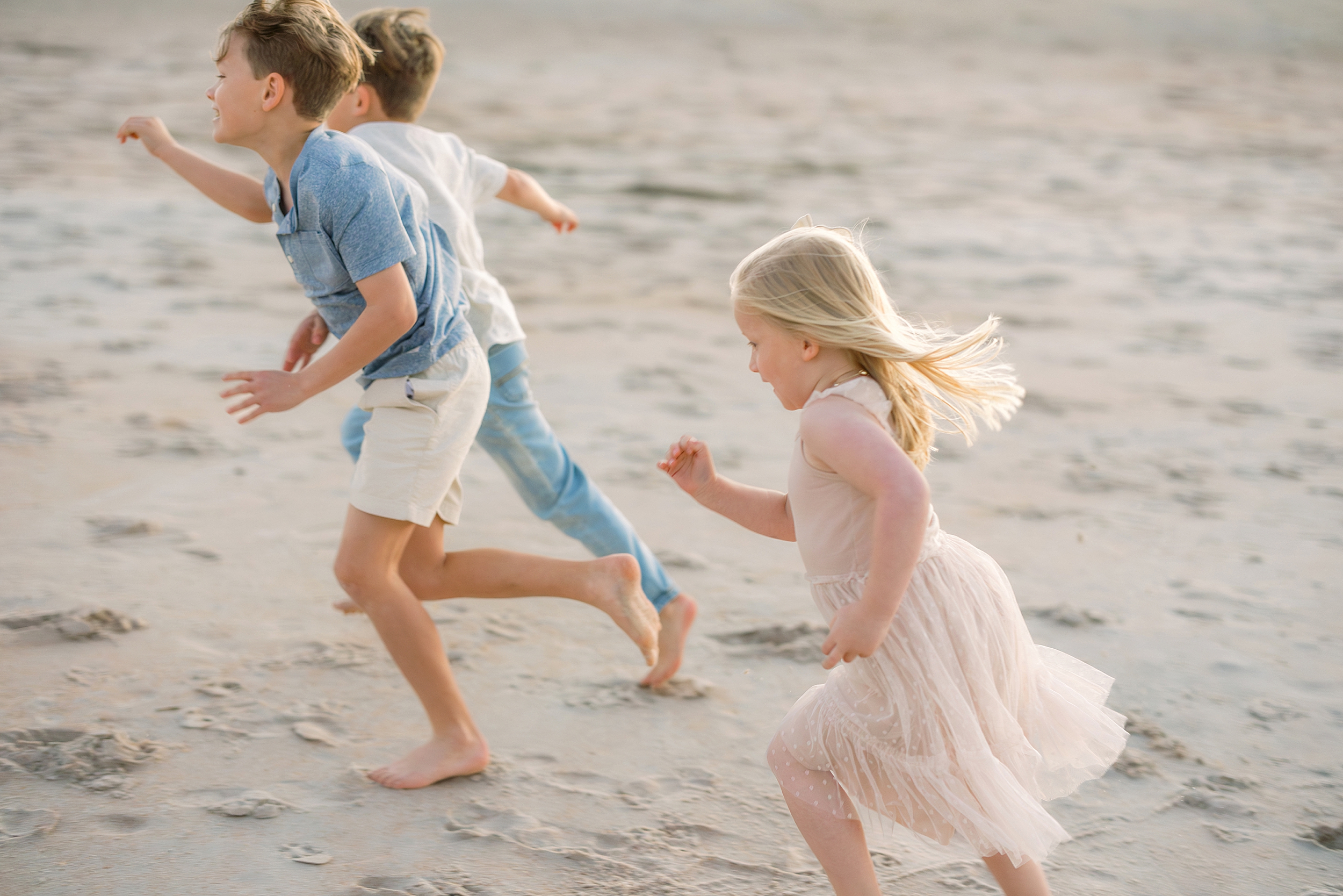 Three children race down the shoreline on the beach in St. Augustine.