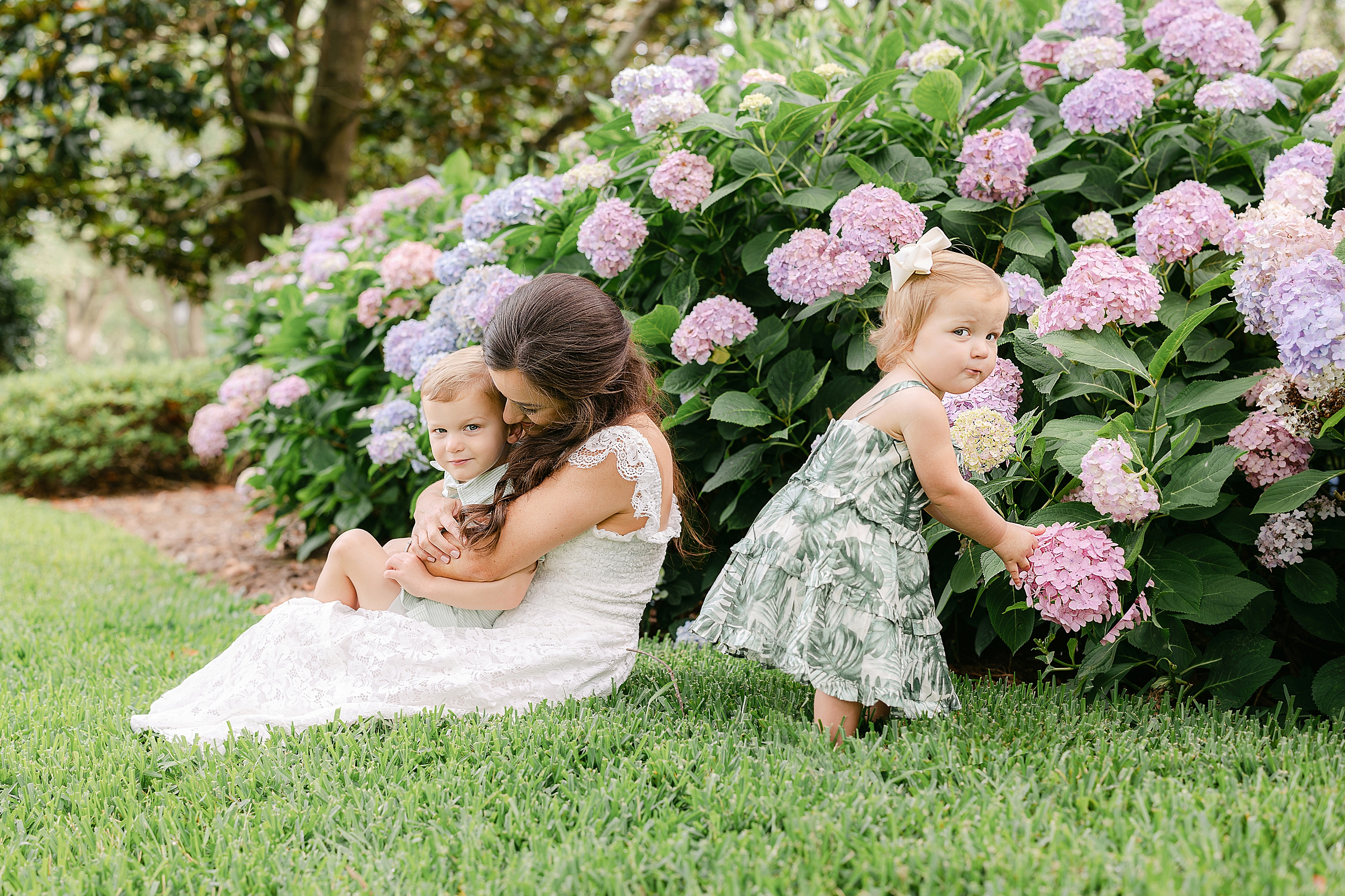 A motherhood portrait of a woman with her son and daughter among the hydrangeas at The Cloister in Sea Island, Georgia.