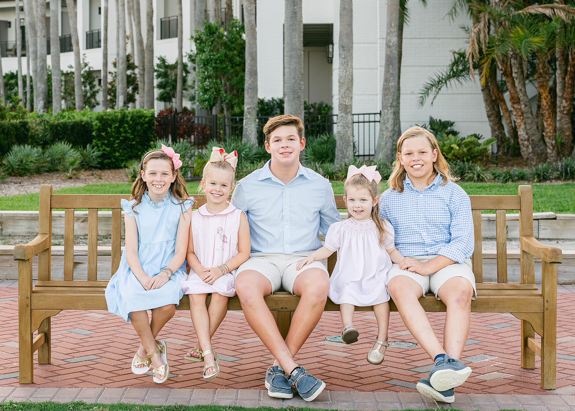 Siblings sit on a bench at sunset on the golf course at Ponte Vedra Beach Inn and Club, Florida.