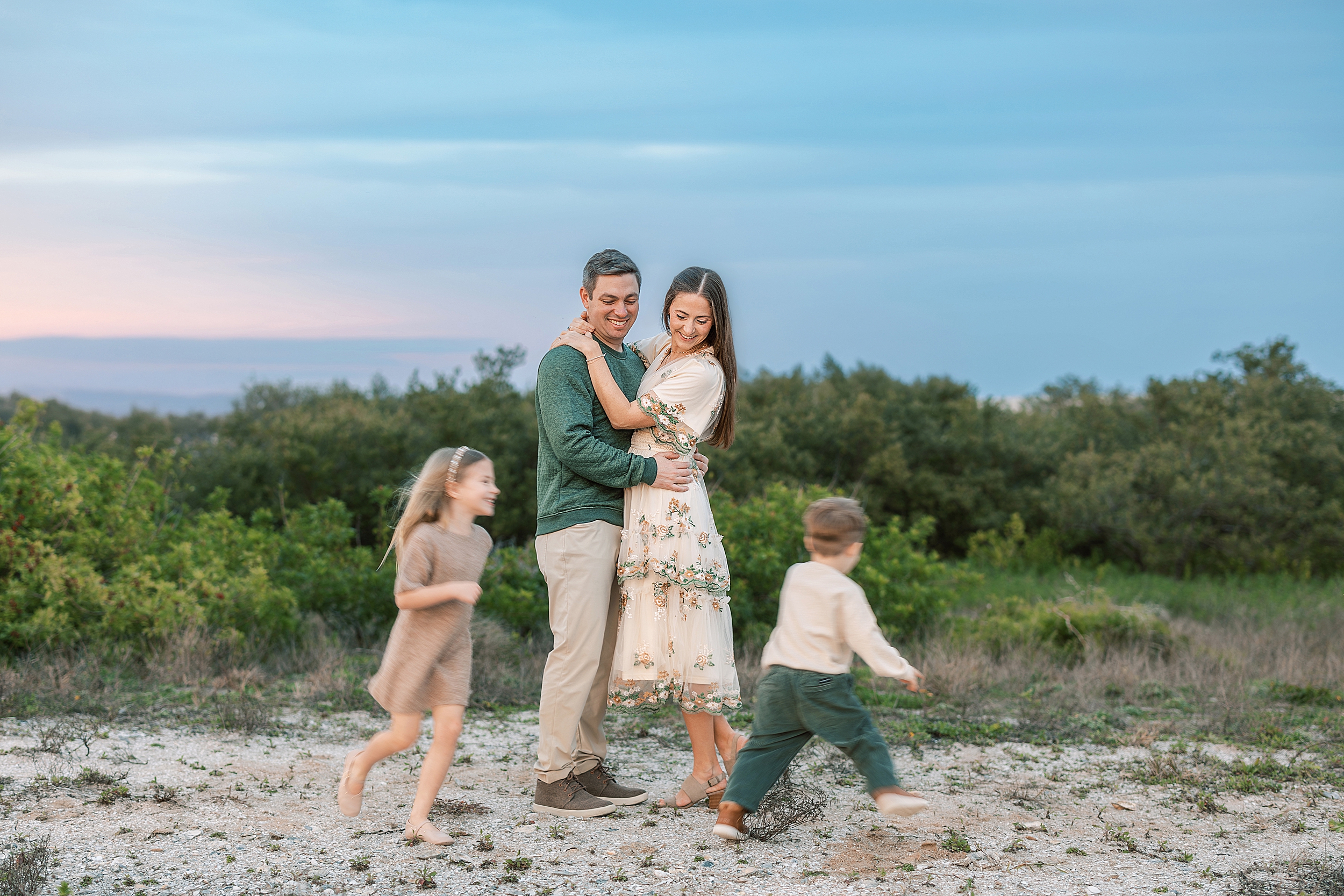 Two children run around their parents at during a sunset near Saint Augustine Beach.