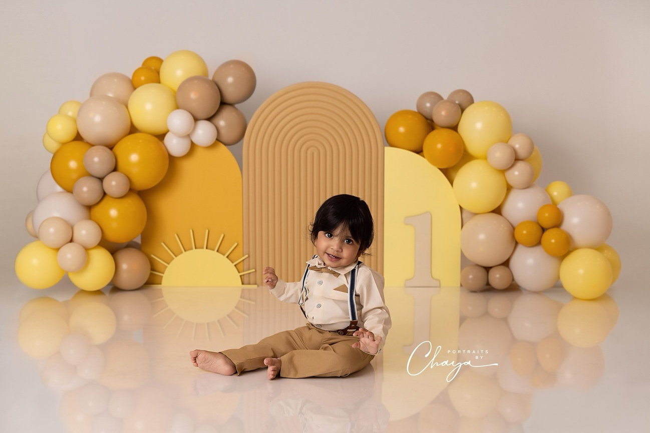 Baby in a yellow and neutral custom first birthday set at Portraits by Chaya