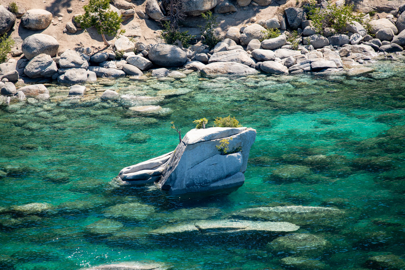 Bonsai rock sits in the crystal clear blue water of Lake Tahoe.
