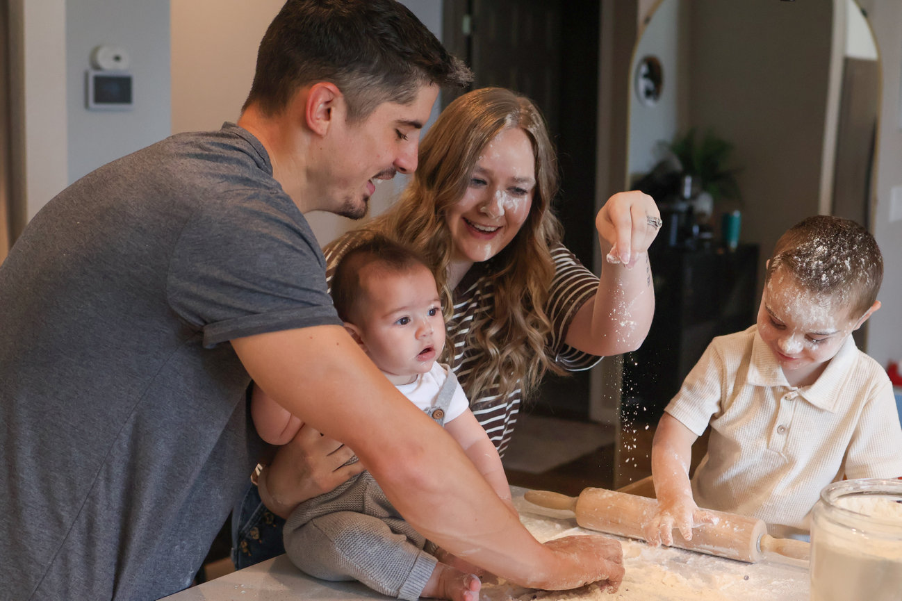 Family gathered around a kitchen counter baking together