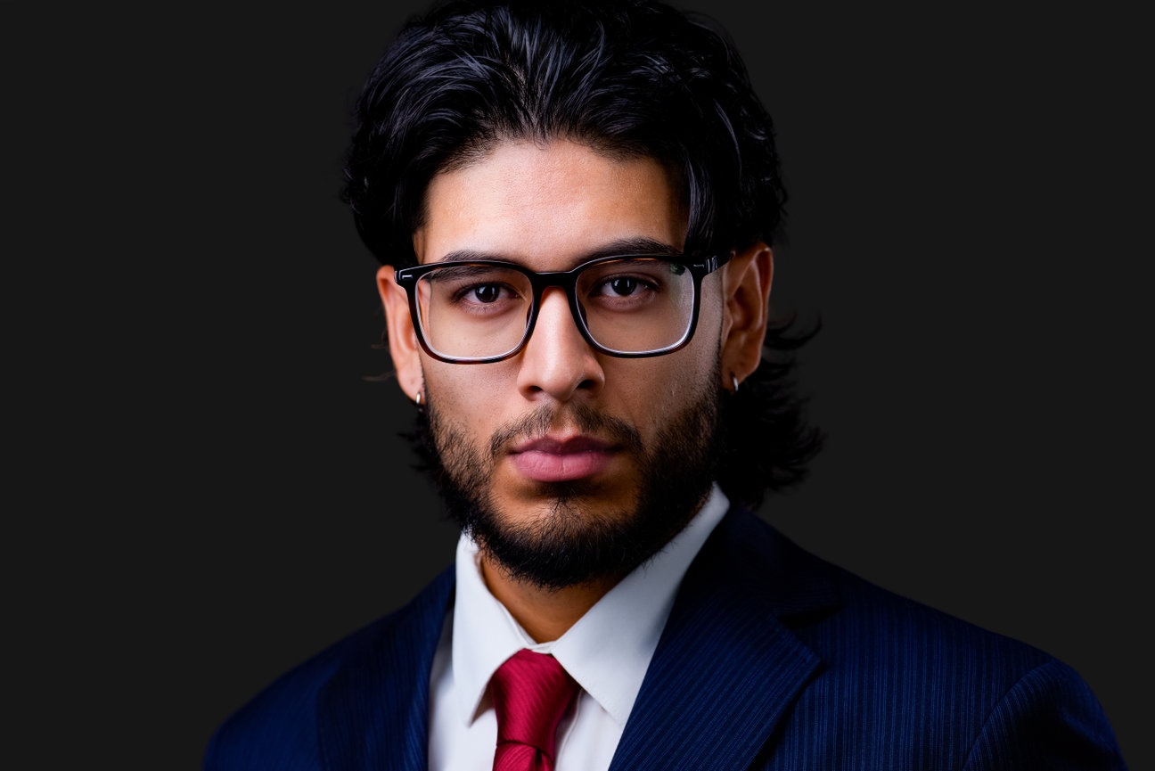 Studio headshot of young professional man in suit and glasses on black background, personal branding session by portrait photographer