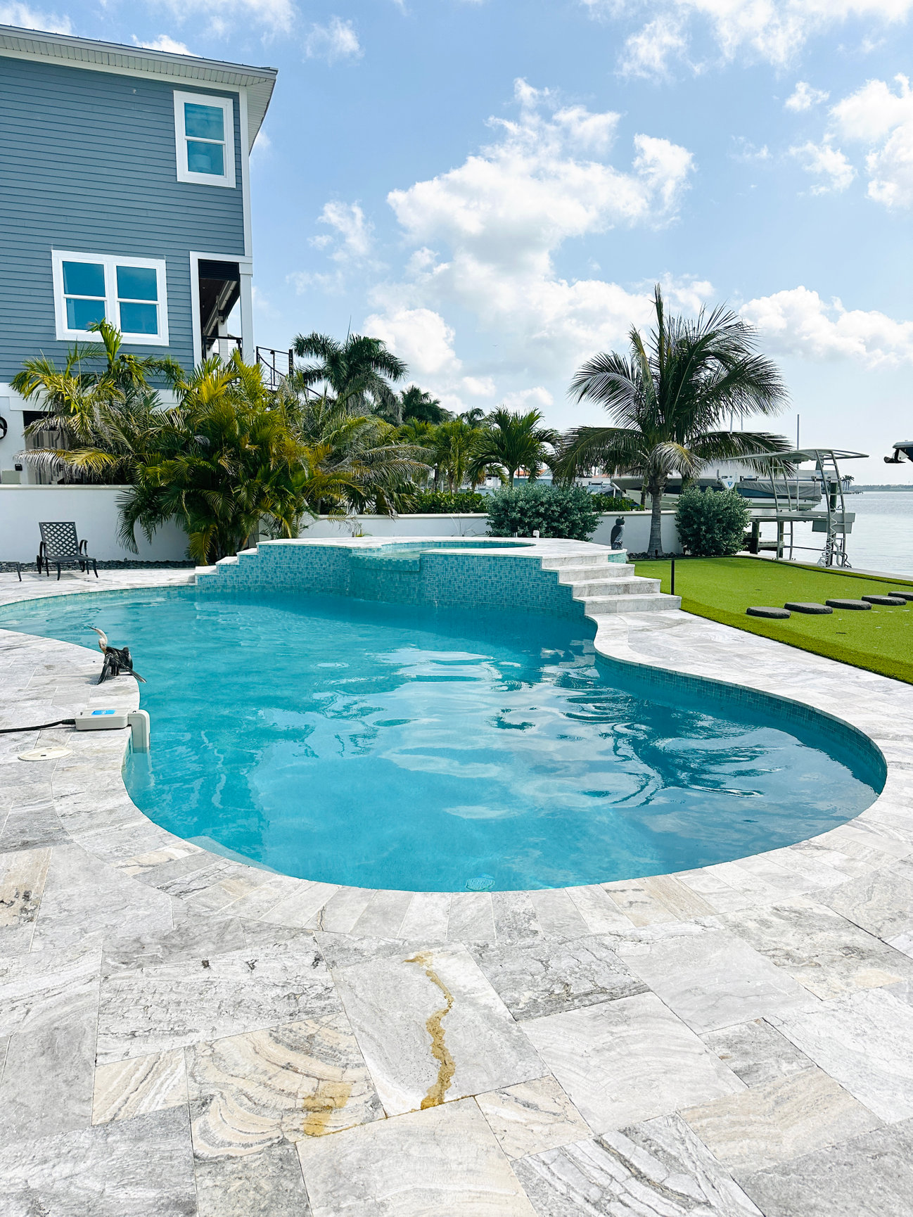 Crystal clear waterfront swimming pool maintained by Playa Pool Pros