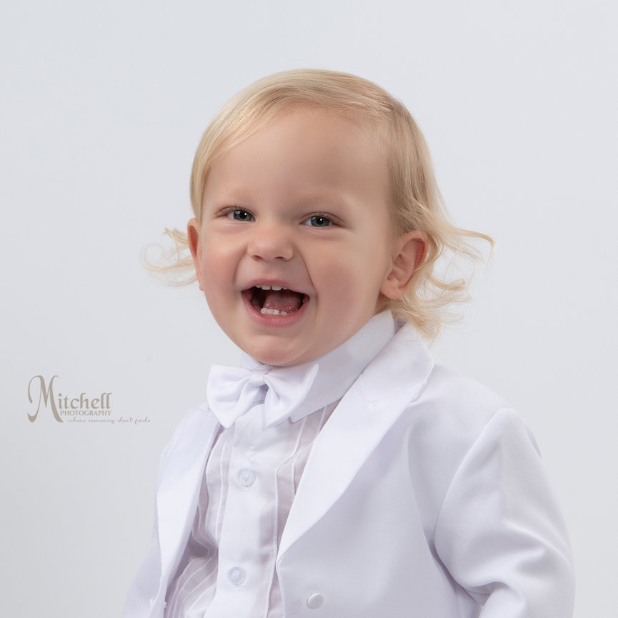 one year old wearing white tux with white background in studio by North Alabama photographer Cindy Mitchell