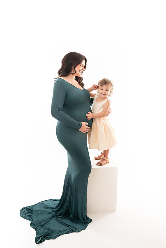 Studio maternity session in Manasquan NJ featuring glowing mother with toddler daughter in coordinating neutral tones
