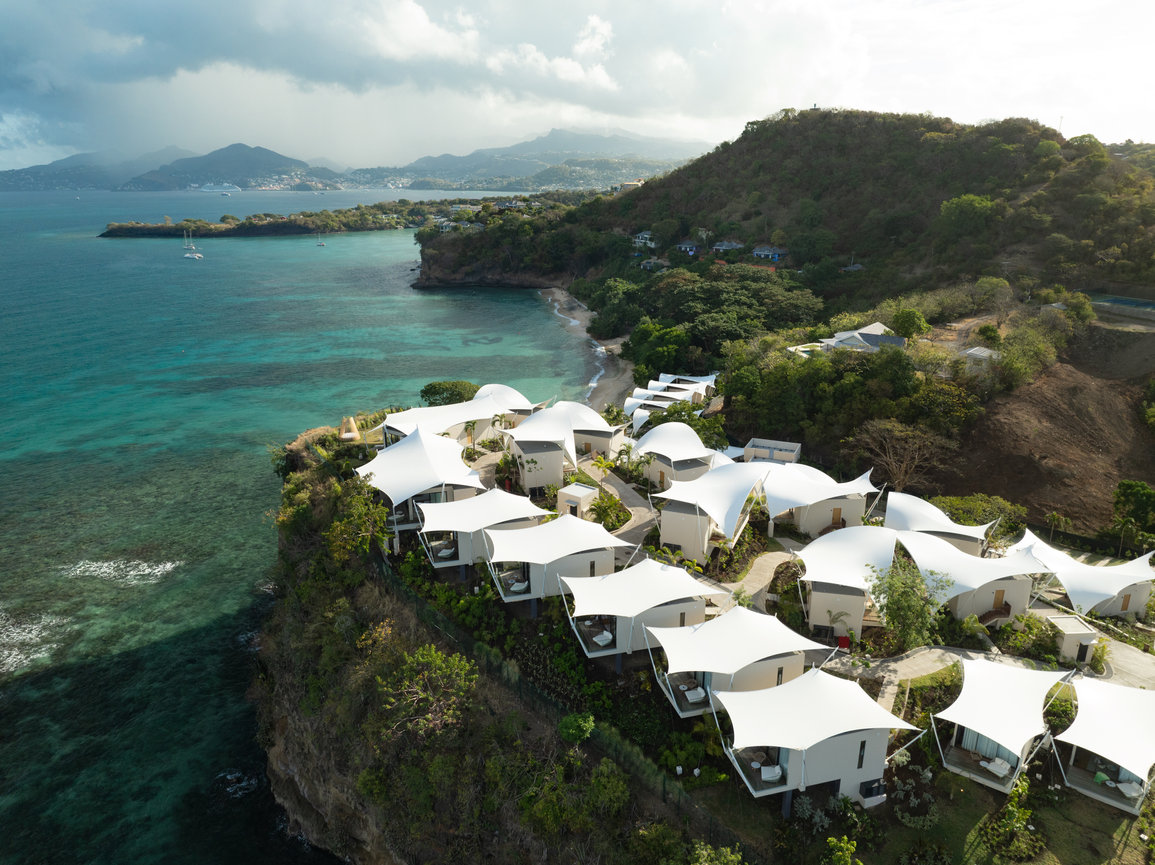 Early morning aerial view of Silversands Beach House property in Granada with Mountains and Ocean backdrop.