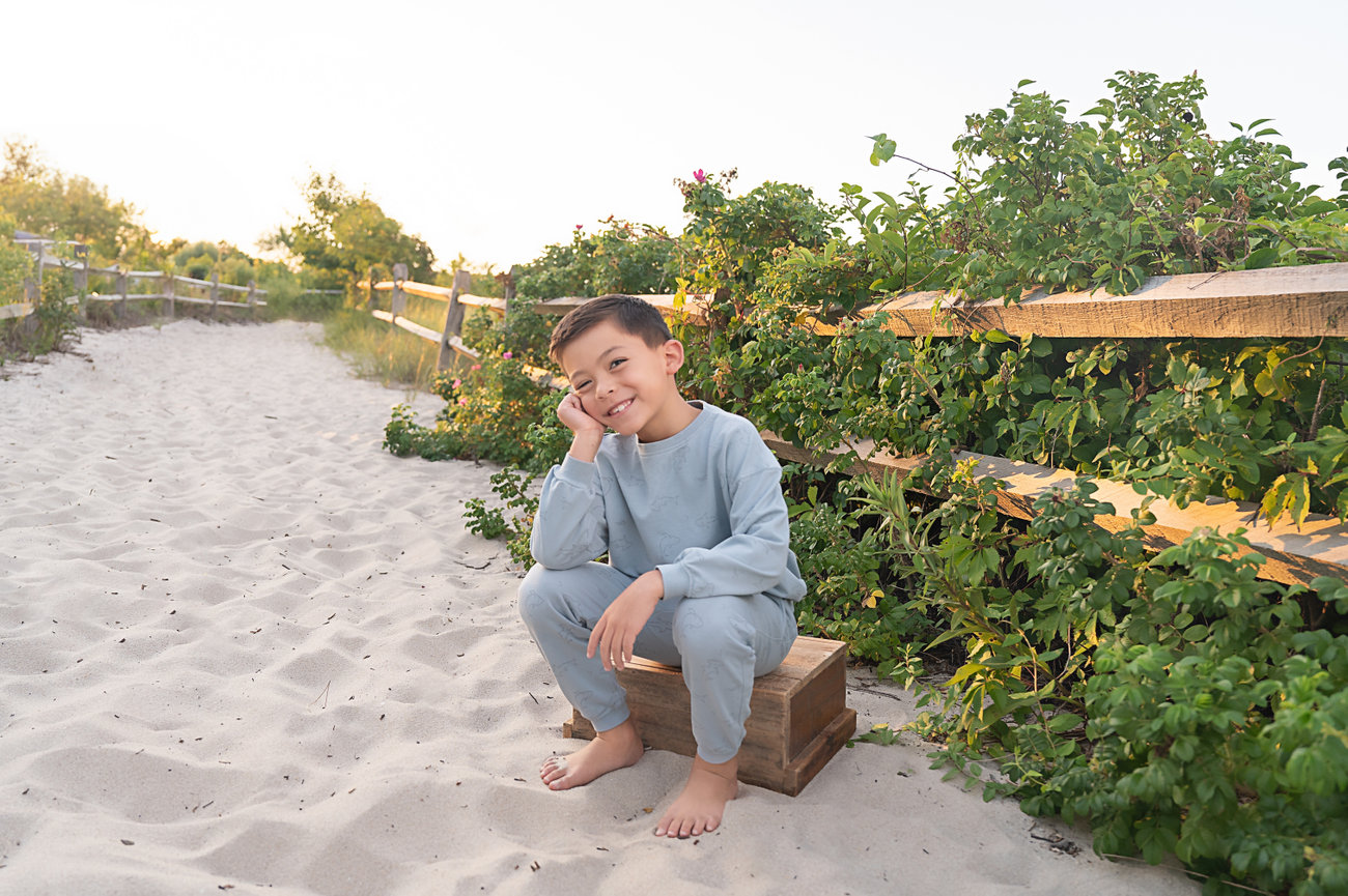 Adorable boy posing in golden light on the beach