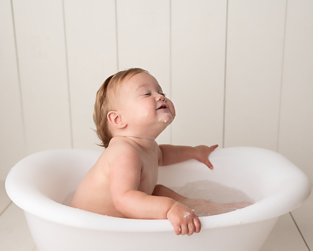 Clean-up time in Colts Neck: baby smiling while soaking in small white tub